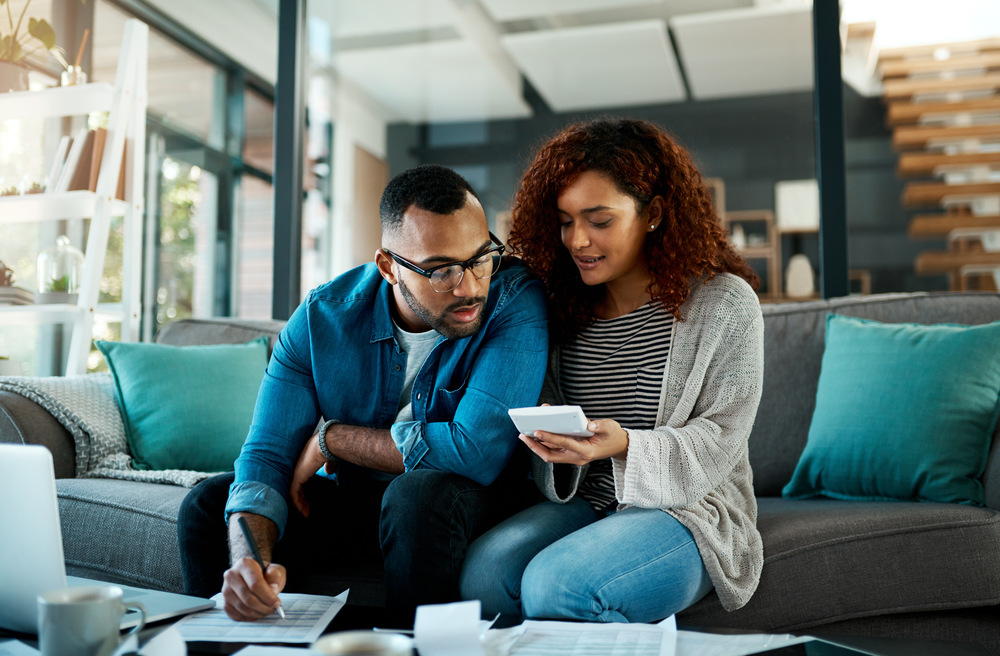 Image d'un couple sur une table regardant un cahier ensemble.